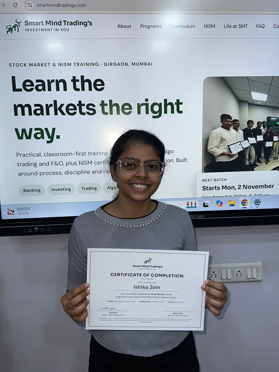 SMT student Ishika holding her Certificate of Completion